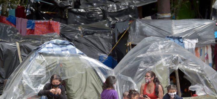 Venezuelan migrants remain at an improvised camp in Bogota on June 9, 2020. - Hundreds of Venezuelan migrants, who are seeking to return to their country, were unable to leave the city because of the measures taken by the government due to the novel coronavirus COVID-19 pandemic. (Photo by Raul ARBOLEDA / AFP)